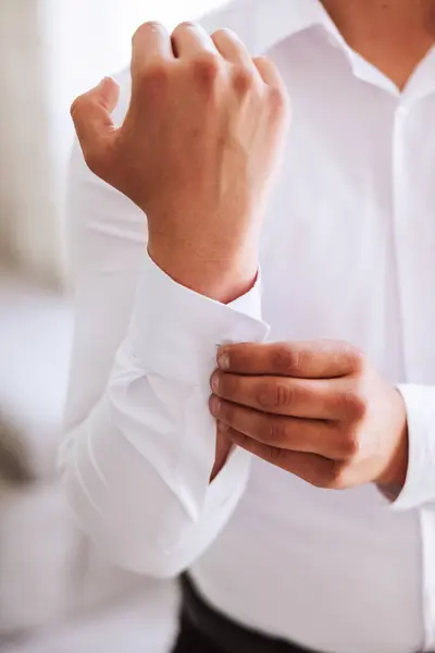 ハンサムなビジネスマンは 自宅でシャツの袖をボタンでボタン化しています 花嫁は結婚式の準備をしている クローズアップ写真 — ストック写真