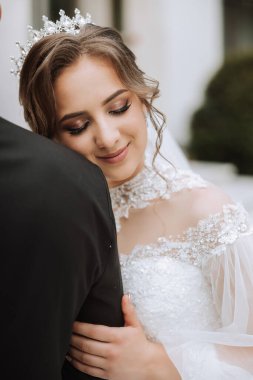 Düğün için. Aşk ve çift düğün için bahçede. Törenin ve bağlılığın kutlanması. Tarihi kaydet. Güven. Gelin ve damat kucaklaşır. Gülümse ve sev. Gelin damadı omuzlarından tutar..