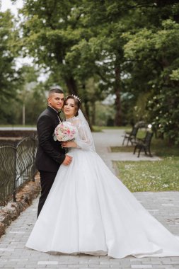 Düğün için. Aşk ve çift düğün için bahçede. Töreni ve bağlılığı kutluyoruz. Tarihi kaydet. Güven. Damat gelini kucaklıyor. Şefkatli öpücükler. Birbirine aşık bir çift. Düğün portresi