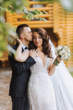 Düğün için. Aşk ve çift düğün için bahçede. Töreni ve bağlılığı kutluyoruz. Tarihi kaydet. Güven. Damat gelini kucaklıyor. Şefkatli öpücükler. Birbirine aşık bir çift. Düğün portresi