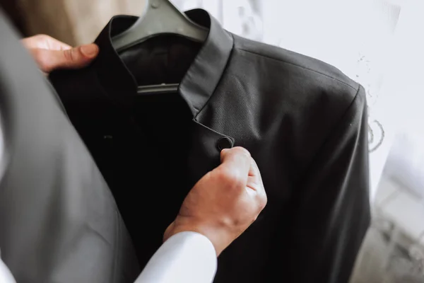 Чоловік Тримає Чорну Куртку Вішалці Руках Наречений Готується Весільної Церемонії — стокове фото
