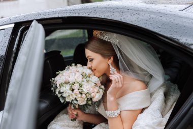 Gelin arabanın camından dışarı bakıyor. Araba vitrininde utangaç bir gelinin yakın plan portresi. Gelin gülümsemesi duyguları