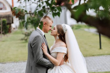 Doğada bir çiftin birbirine bakarken çekilmiş yakın plan fotoğrafı. Gelin ve damat doğanın ortasında birbirlerine bakıyorlar. Gözlerinde şefkat ve sevgi.