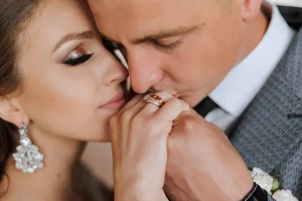 Wedding kiss. Groom kisses bride\'s hand. Weddng love. Close-up of a young man kissing his wife\'s hand with gold ring while making a marriage proposal.