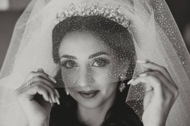 Beyaz gelinlik içinde duvak tutan genç bir gelin otel odasında esmer gelin portresi, düğünden önceki sabah..