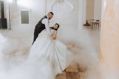 Gelin ve damadın düğün dansı. Gelin ve damadın ilk dansı zarif bir düğün salonunda ağır duman ve havai fişeklerin kullanıldığı konfeti....