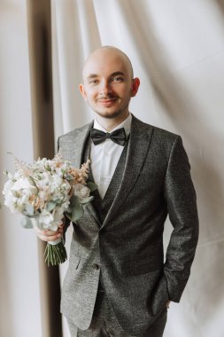 Düğün töreninden önce evde genç bir damadın portresi. Klasik takım elbiseli yakışıklı bir adam. Erkek portresi.