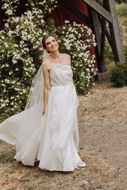 Uzun treni olan güzel bir gelin. Beyaz elbiseli gelin ve doğada uzun bir tren bir yaz günü. Yaz düğünü.