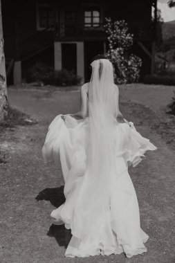 Uzun treni olan güzel bir gelin. Beyaz elbiseli gelin ve doğada uzun bir tren bir yaz günü. Yaz düğünü.