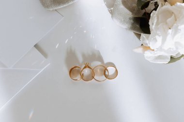 Gelinin nişan yüzüğü, topuklular, parfüm. Gelinin düğün detayları. Çiçekler. Güzel ışık. Gelinlik