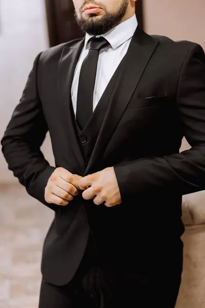 Man fastens the buttons. The groom in a suit. Close up. Man is buttoning his vest. Perfect to the last detail. Modern businessman.