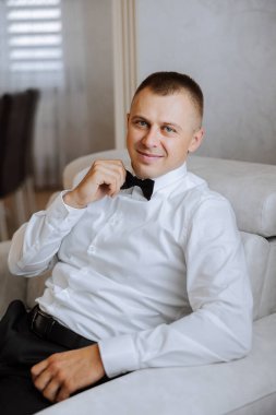 Düğün töreninden önce evde genç bir damadın portresi. Klasik takım elbiseli yakışıklı bir adam. Erkek portresi.