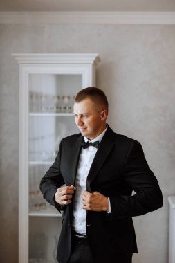 Adam düğmeleri bağlar. Takım elbiseli damat. Kapatın. Adam yeleğinin düğmelerini ilikliyor. En ince ayrıntısına kadar mükemmel. Modern iş adamı.