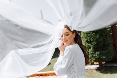 Beyaz gelinlik içinde duvak tutan genç bir gelin otel odasında esmer gelin portresi, düğünden önceki sabah..