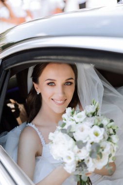 Gelin arabanın camından dışarı bakıyor. Araba vitrininde utangaç bir gelinin yakın plan portresi. Gelin gülümsemesi duyguları