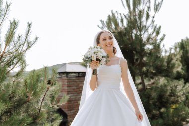 güzel gelin düğün çiçek kokulu, gelinlik çekici kadın. mutlu yeni evli bir kadın. gelin düğün makyaj ve saç modeli ile. Gelin gülümseyen. düğün günü. çok güzel bir gelin. evlilik.