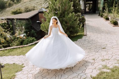 Uzun treni olan güzel bir gelin. Beyaz elbiseli gelin ve doğada uzun bir tren bir yaz günü. Yaz düğünü.