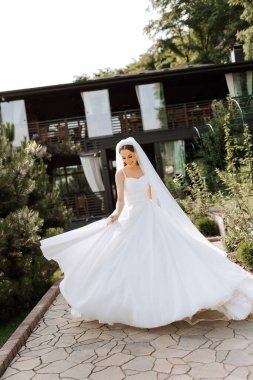 Uzun treni olan güzel bir gelin. Beyaz elbiseli gelin ve doğada uzun bir tren bir yaz günü. Yaz düğünü.