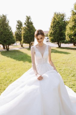 Uzun treni olan güzel bir gelin. Beyaz elbiseli gelin ve doğada uzun bir tren bir yaz günü. Yaz düğünü.