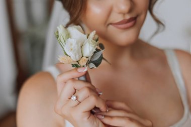 Çiçek yaka çiçekleri gelinin elinde. Düğün detayları. Gelin ve damadın ilk buluşması. Gelin damadı bekliyor..