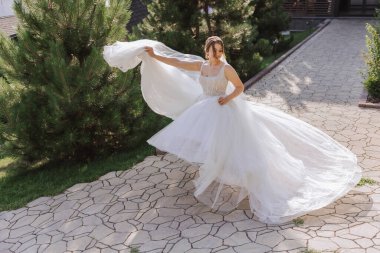 Uzun treni olan güzel bir gelin. Beyaz elbiseli gelin ve doğada uzun bir tren bir yaz günü. Yaz düğünü.