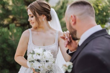 Düğün öpücüğü. Damat gelinin elini öpüyor. Kucaklaşma aşkı. Evlilik teklifi yaparken karısının elini altın yüzükle öpen genç bir adamın yakın çekimi..