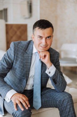 Düğün töreninden önce evde genç bir damadın portresi. Klasik takım elbiseli yakışıklı bir adam. Erkek portresi.