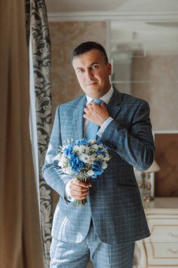 Düğün töreninden önce evde genç bir damadın portresi. Klasik takım elbiseli yakışıklı bir adam. Erkek portresi.