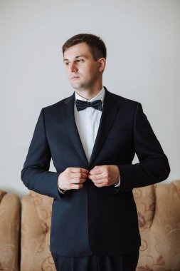 Düğün töreninden önce evde genç bir damadın portresi. Klasik takım elbiseli yakışıklı bir adam. Erkek portresi.