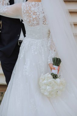 Gelin elinde bir buket beyaz çiçek ve yakın plan fotoğraf tutuyor. Düğün detayları. Yüksek kalite fotoğraf