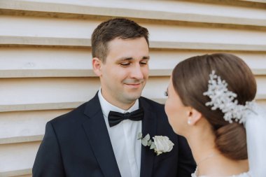 Doğada bir çiftin birbirine bakarken çekilmiş yakın plan fotoğrafı. Gelin ve damat doğanın ortasında birbirlerine bakıyorlar. Gözlerinde şefkat ve sevgi.