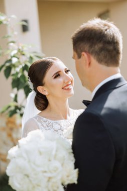 Doğada bir çiftin birbirine bakarken çekilmiş yakın plan fotoğrafı. Gelin ve damat doğanın ortasında birbirlerine bakıyorlar. Gözlerinde şefkat ve sevgi.