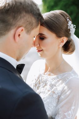 Doğada bir çiftin birbirine bakarken çekilmiş yakın plan fotoğrafı. Gelin ve damat doğanın ortasında birbirlerine bakıyorlar. Gözlerinde şefkat ve sevgi.