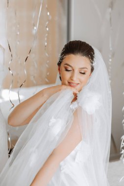 Sabahları beyaz gelinlik içinde yatakta oturan güzel bir gelin. Moda fotoğrafı, sabahlık giymiş güzel bir kadın. Moda, cazibe konsepti