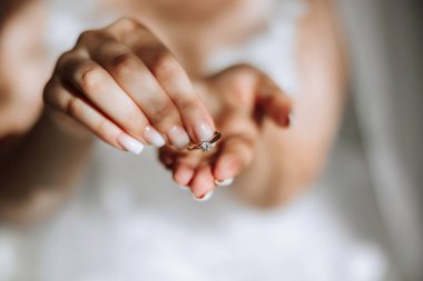 Pahalı bir yüzük ve güzel bir manikürle genç bir kadının şefkatli elleri. Kadın elinin yakın plan fotoğrafı.