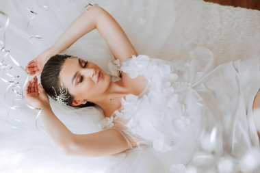 Güzel, genç bir gelin kız, güzel bir bornozla yatıyor. Düğün töreninden önce gelinin sabahı.