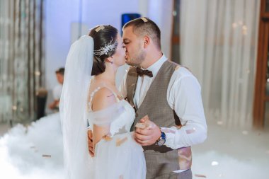 Gelin ve damadın düğün dansı. Gelin ve damadın ilk dansı zarif bir düğün salonunda ağır duman ve havai fişeklerin kullanıldığı konfeti....