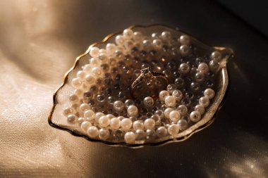 Gelinin nişan yüzüğü, topuklular, parfüm. Gelinin düğün detayları. Çiçekler. Güzel ışık. Gelinlik