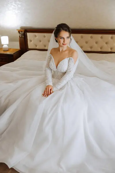 酒店房间里新娘的画像 一个年轻貌美的姑娘穿着一件白色婚纱 现代婚礼发型 自然妆容 — 图库照片