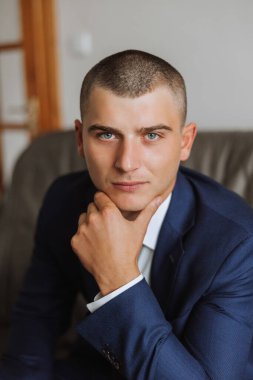 Düğün töreninden önce evde genç bir damadın portresi. Klasik takım elbiseli yakışıklı bir adam. Erkek portresi.