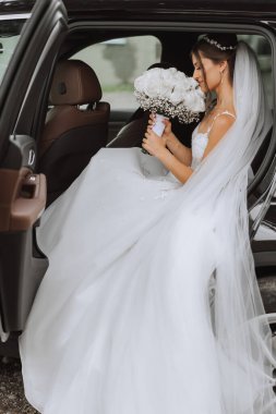 Gelin arabanın camından dışarı bakıyor. Araba vitrininde utangaç bir gelinin yakın plan portresi. Gelin gülümsemesi duyguları