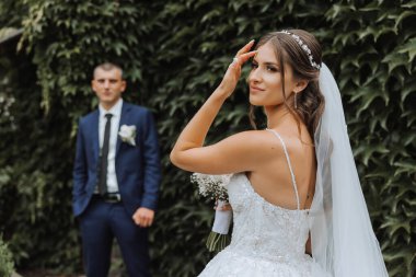 Gelin zarif, gür, beyaz bir gelinlik ve uzun bir duvak giyer ve damadı için hazırdır. Gelin ve damadın ilk buluşması.