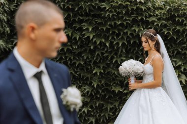 Gelin zarif, gür, beyaz bir gelinlik ve uzun bir duvak giyer ve damadı için hazırdır. Gelin ve damadın ilk buluşması.