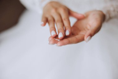 Pahalı bir yüzük ve güzel bir manikürle genç bir kadının şefkatli elleri. Kadın elinin yakın plan fotoğrafı.