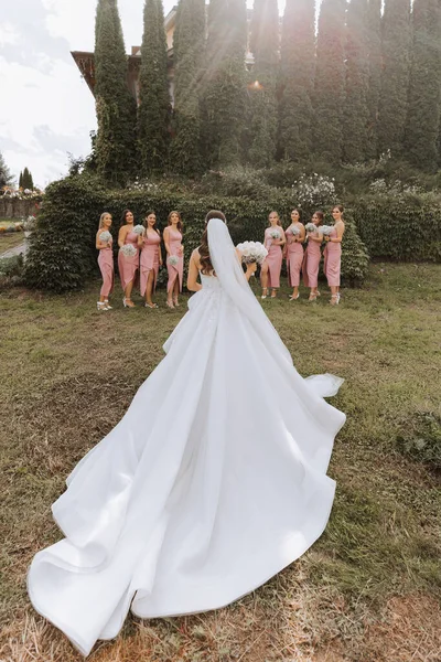 신부와 신부는 나무의 배경에 대하여 카메라에 그들의 돌렸다 드레스에 여자들은 — 스톡 사진
