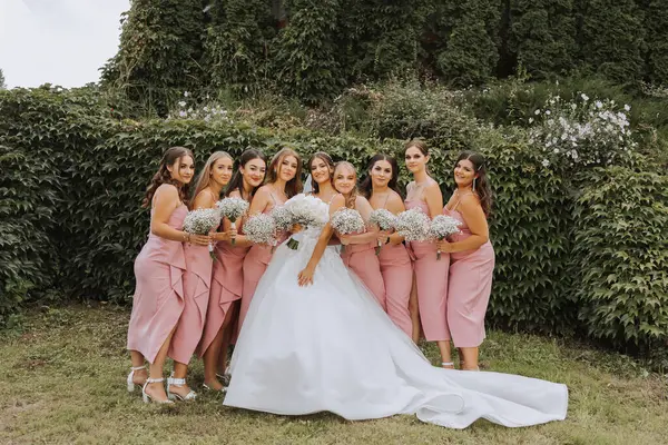 신부와 일치하는 드레스에 그녀의 들러리는 그들의 꽃다발 똑같은 소녀들이 결혼식을 — 스톡 사진
