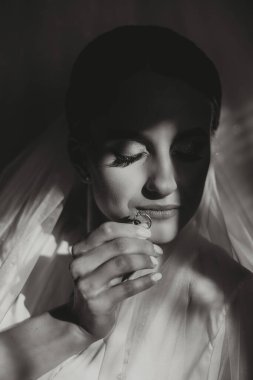 Modern bir manikür ve güneş ışığıyla bir kadının parmağına takılmış zarif bir elmas yüzüğün yakın çekimi. Aşk ve düğün kavramı. Yumuşak ve seçici odak.