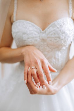 Modern bir manikür ve güneş ışığıyla bir kadının parmağına takılmış zarif bir elmas yüzüğün yakın çekimi. Aşk ve düğün kavramı. Yumuşak ve seçici odak.