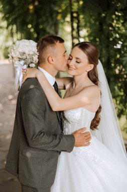 Genç bir gelin ve damat sonbahar güneşinin ışınlarında şefkatle kucaklaşır. Şefkatli ve güzel genç kız gelin. Bir adam sevgilisini öper. Güzel bir bahçenin arka planında