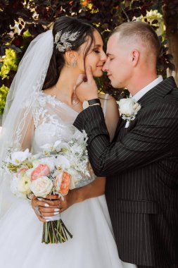 Genç bir gelin ve damat sonbahar güneşinin ışınlarında şefkatle kucaklaşır. Şefkatli ve güzel genç kız gelin. Bir adam sevgilisini öper. Güzel bir bahçenin arka planında